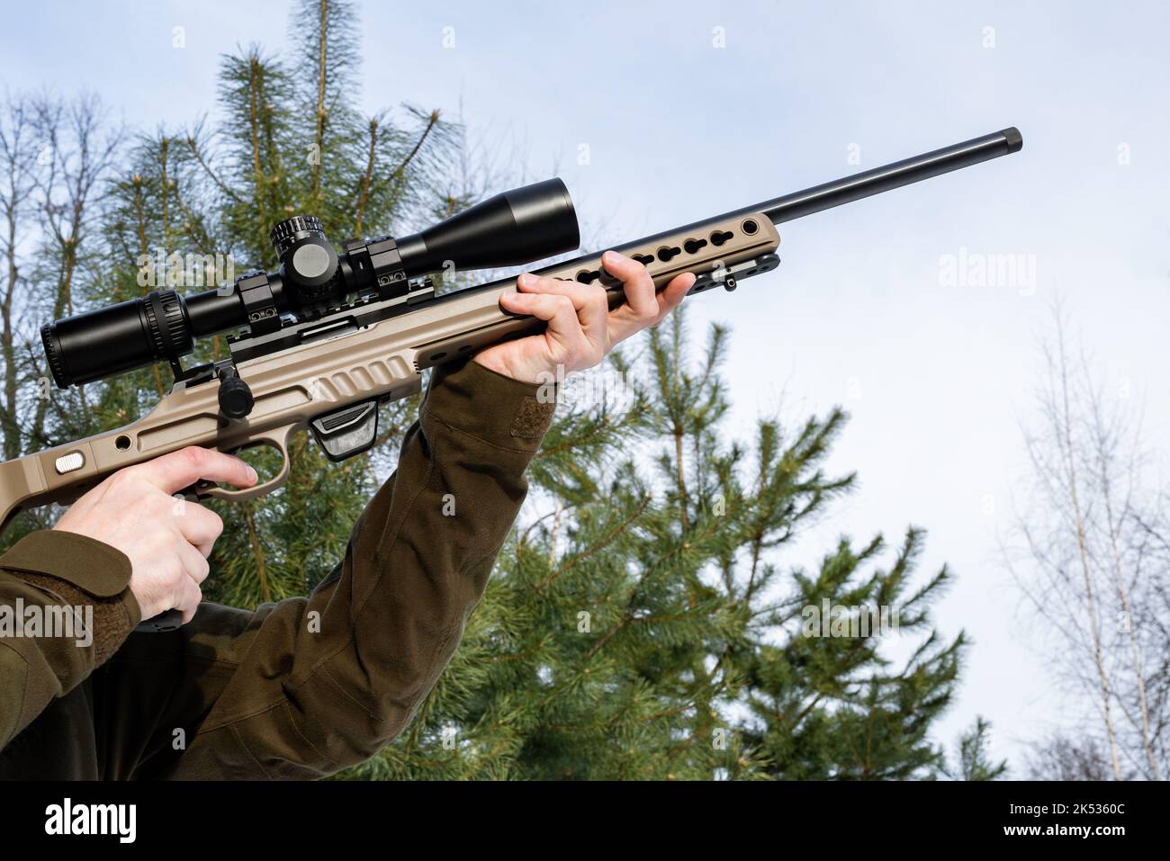 A sniper rifles from a rifle with an optical sight in man`s hands sunny winter day Stock Photo